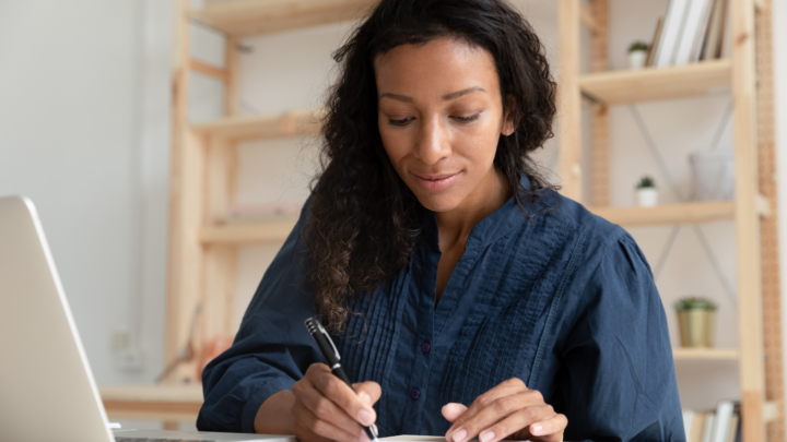 professional woman writing at desk